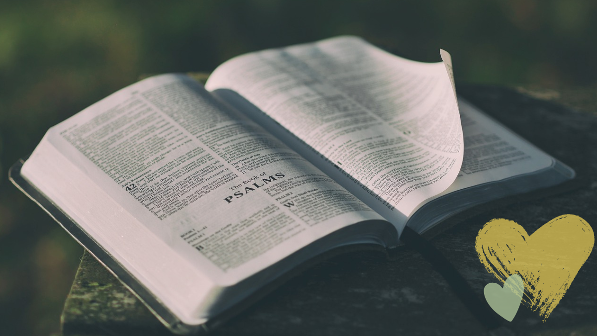 Bible open to the Psalms with yellow and green heart in corner of the picture. 