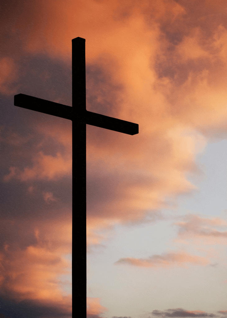 Christian cross in front of pink sky